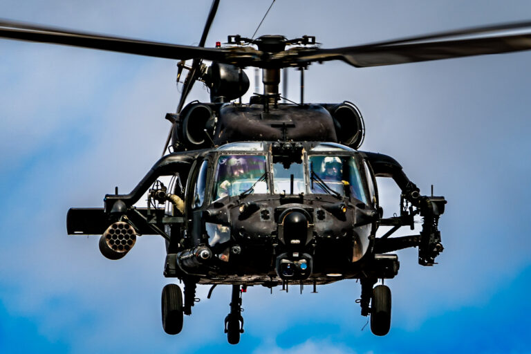 Military helicopter flying in clear sky.